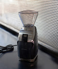 Coffee grinder on a dark surface with a light background