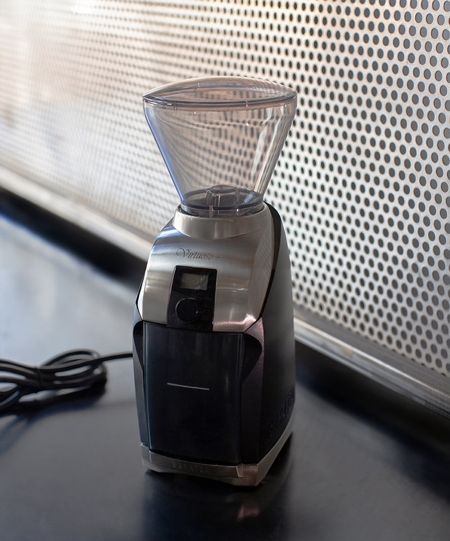 Coffee grinder on a dark surface with a light background