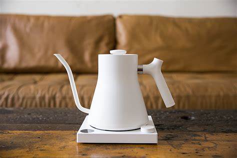 A white Stagg EKG PRO Electric Kettle with a gooseneck spout on a square base with a digital display.