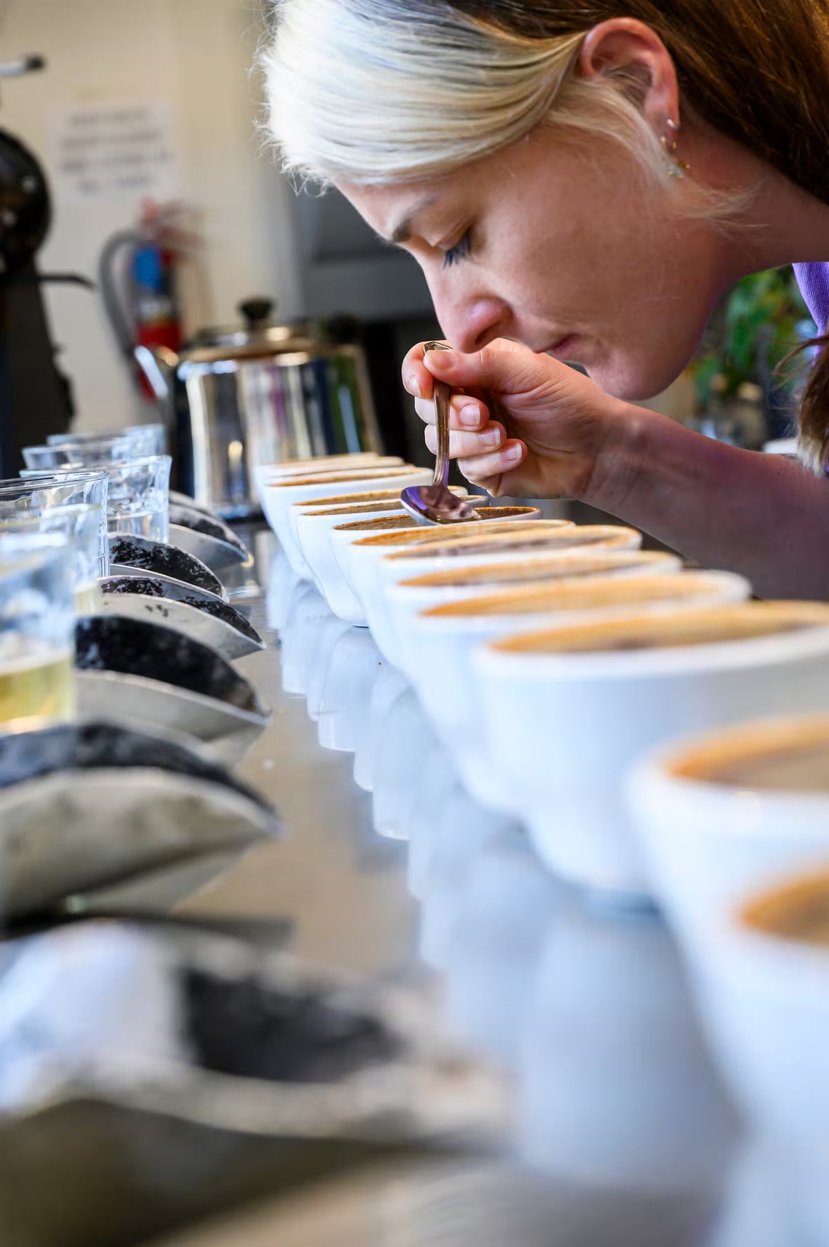Person tasting coffee at a coffee shop