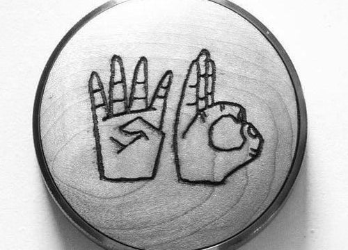 BT Wedge Espresso Distribution Tool, a circular metal tool featuring a laser-etched design of two hands spelling WD in American Sign Language.