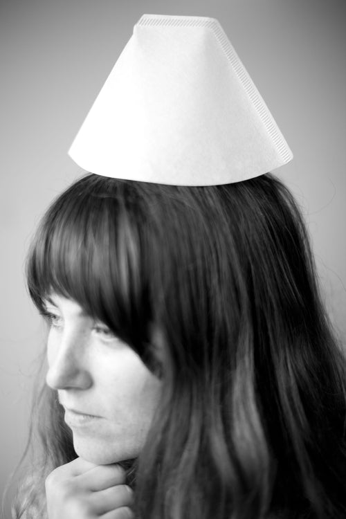 A person with long hair wearing a cone-shaped white Bonmac #2 White Paper Filter on their head like a hat.