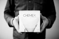 A person holds a square box of Chemex 8 Cup Filters featuring an illustration of a pour-over coffee maker.