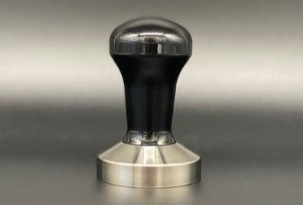 A stainless steel tamper with a black power-coated handle, designed by Reg Barber.